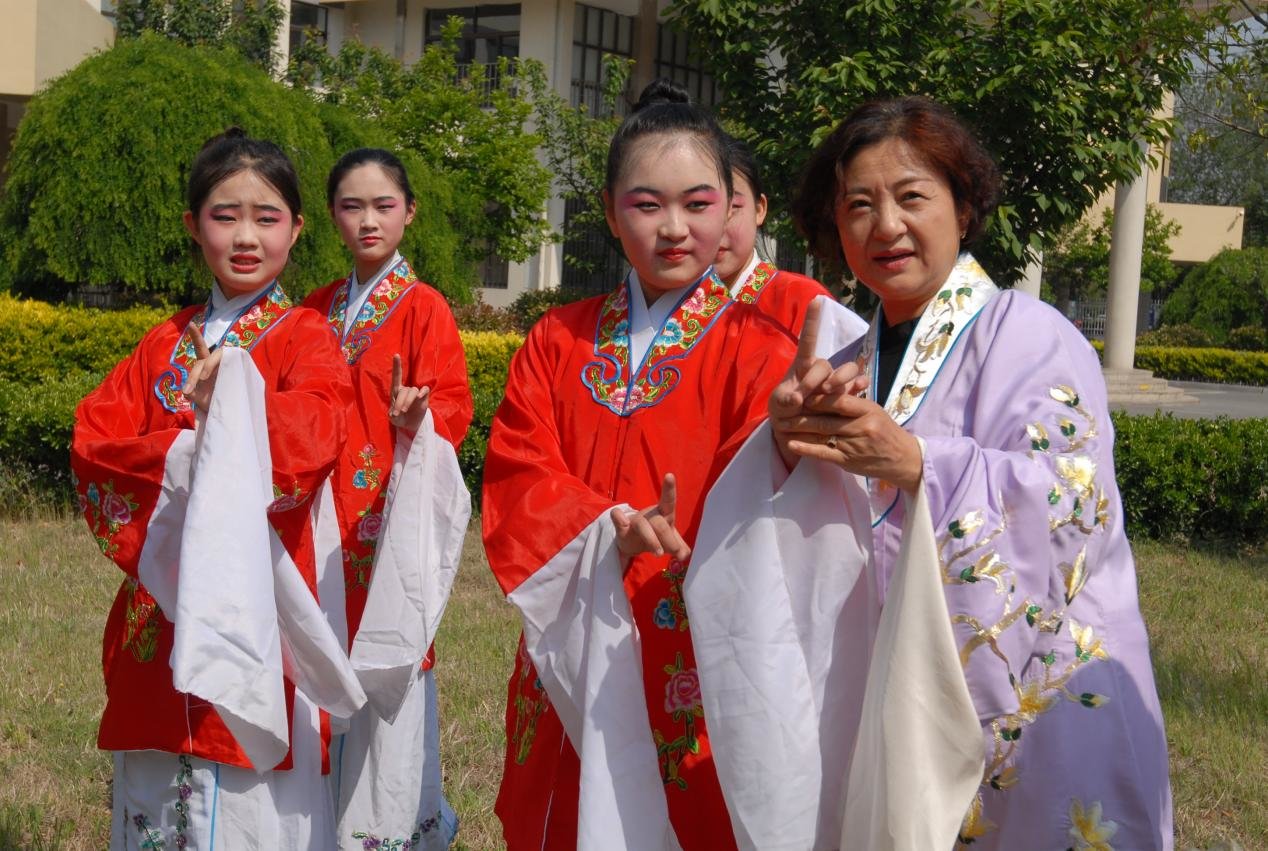 5月15日，在青岛市即墨区第四实验小学，国家级非遗项目柳腔传承人袁玲(右一）在指导学生进行戏曲形体训练。