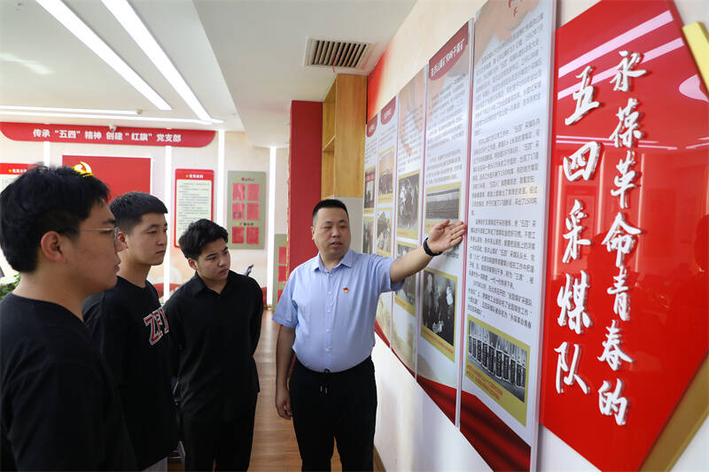 ▲ 正通煤业公司五四采煤队党支部副书记李峰结合队史为职工介绍品牌创建内涵
