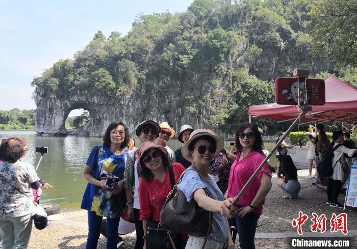 资料图：游客在桂林象山景区观光留影。 唐梦宪 摄