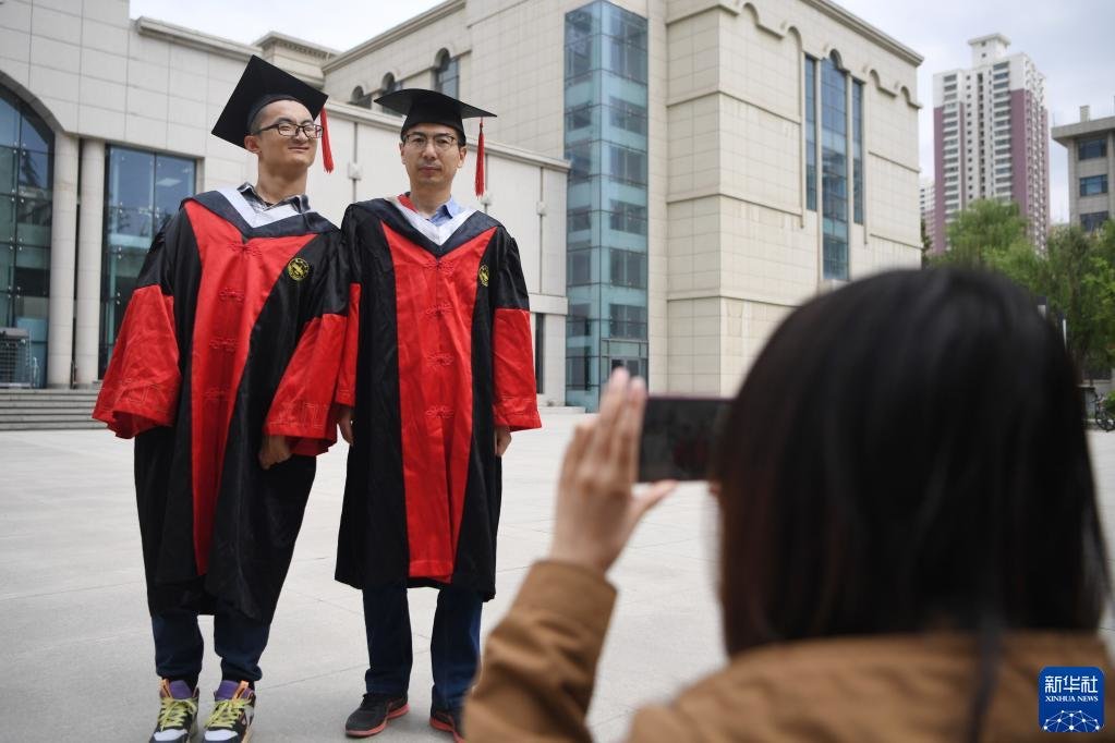 谢炎廷（左）和同学在校园里拍照留念（5月10摄） 新华社记者 陈斌 摄