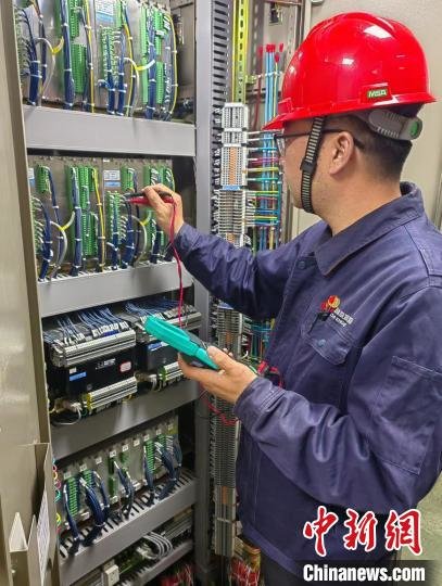 图为甘肃龙源风力发电有限公司玉门区域维保中心副主任任乐文进行继电保护装置故障排查。(资料图) 甘肃龙源风力发电有限公司供图