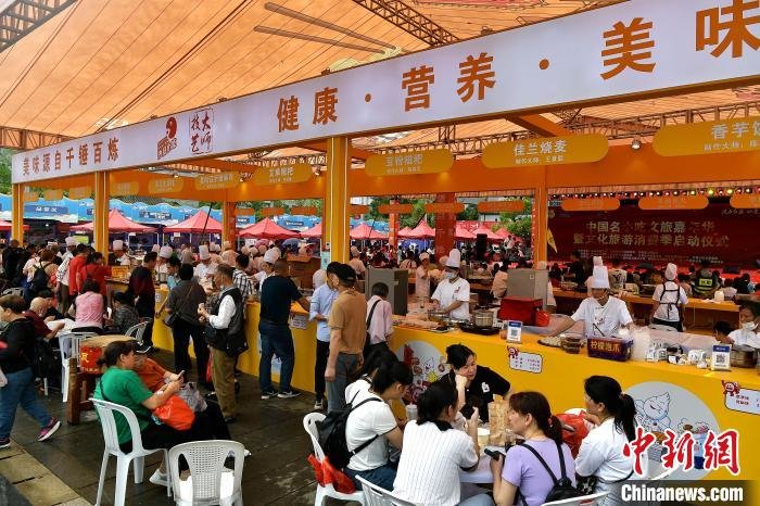 图为中国名小吃文旅嘉年华活动吸引了许多民众前来品尝美食。　张斌 摄