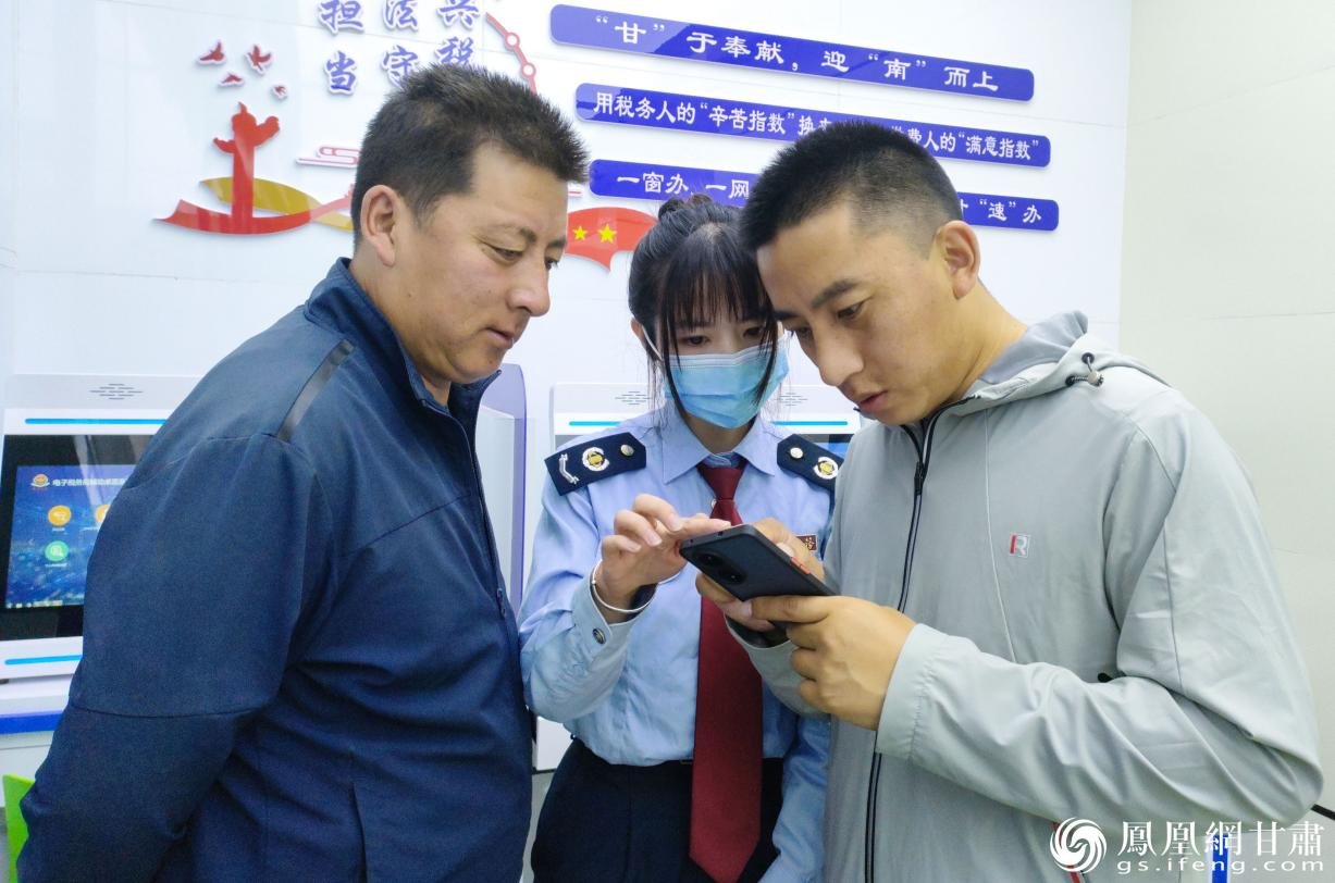 甘肃省甘南州合作市税务局办税服务厅工作人员王倩文（中）指导其特才让（右）办理涉税业务 马斌 摄