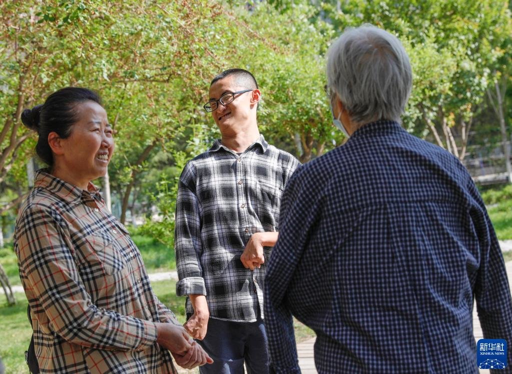 在兰州大学，谢炎廷和母亲刘小凤（左）与一位关心谢炎廷近况的奶奶交谈（5月12日摄）。新华社记者 方欣 摄