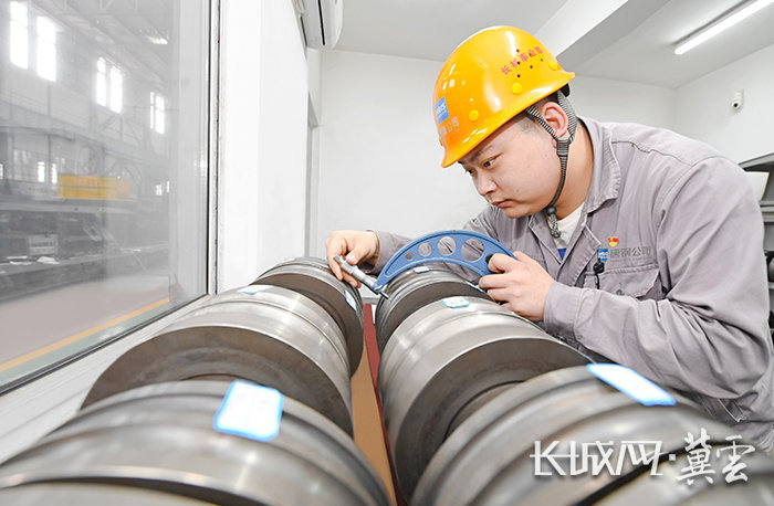 河钢集团唐钢公司长材事业部党员骨干在测量轧制吨位提升后的精轧辊环尺寸精度。赵辉 周跃 摄