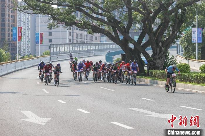 图为男子山地精英组选手从城市高架桥上疾驰而下。　刘力鑫 摄