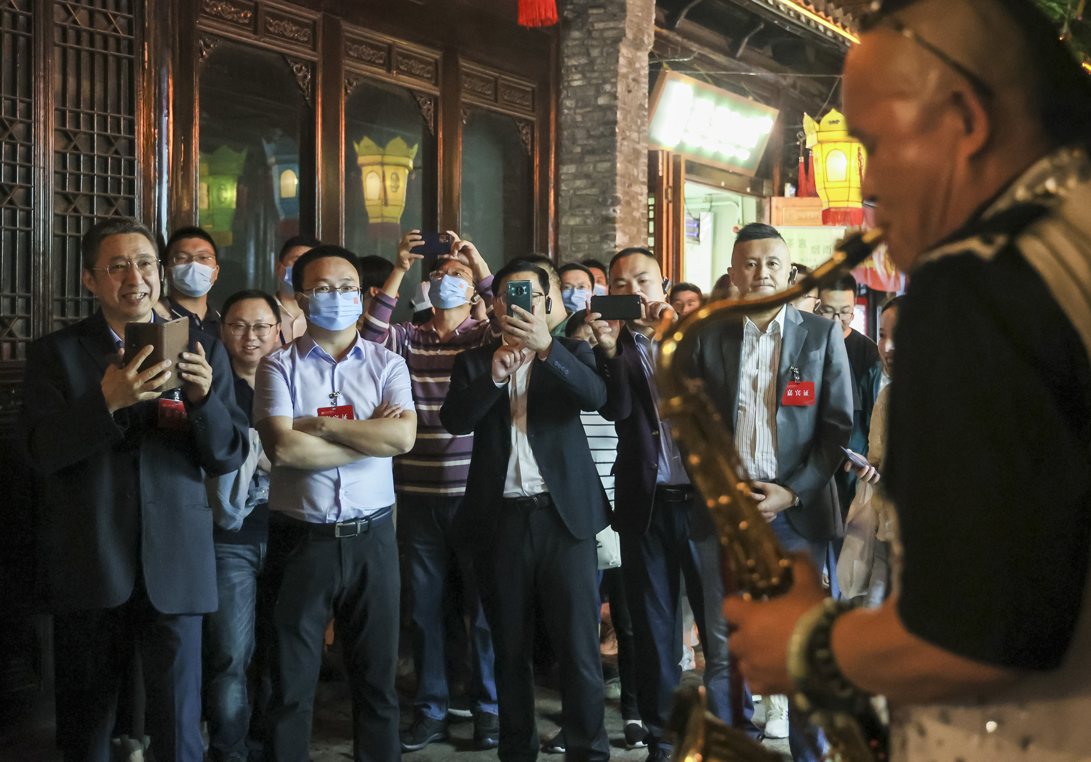 西津渡古镇上街头艺人正在表演，引人驻足围观。谢道韫/图