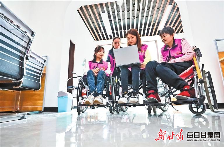 在张掖市残疾人网络就业基地，工作人员在指导新员工熟悉业务。