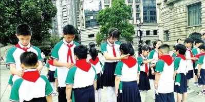 5月31日，大兴路小学在江汉关大楼下举行入队仪式，新队员第一次戴上鲜艳的红领巾。