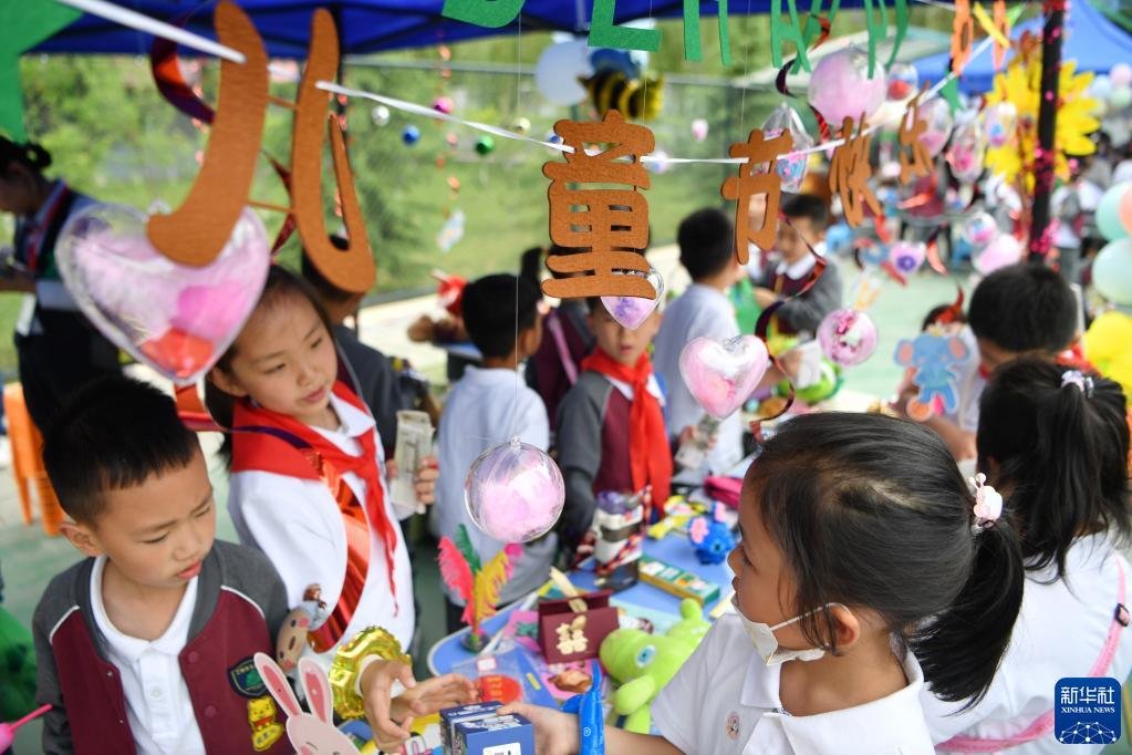 5月31日，兰州市东郊学校的小学生在创意义卖市集上挑选物品。新华社记者 陈斌 摄