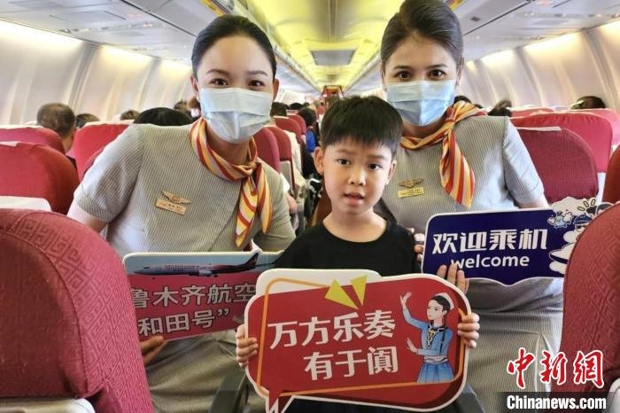图为空乘人员和旅客共同见证飞机首航这一重要时刻。 乌鲁木齐航空供图