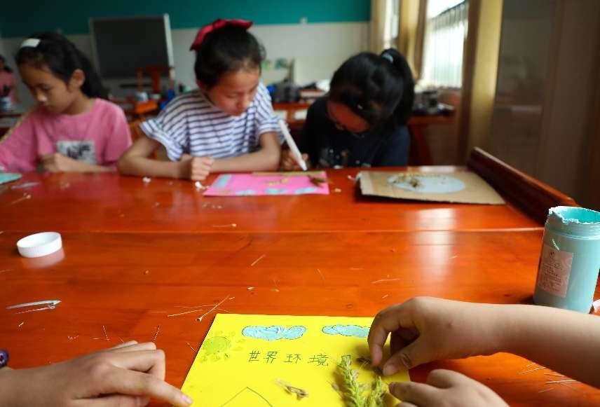 （6月2日，在肥西县铭传乡中心学校，学生正在用废旧物品制作环保手工艺品。 刘少芬 摄）