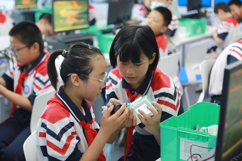 邯山区代召实验小学学生在邯郸人工智能教育基地体验组装机器人。(李昊 摄)