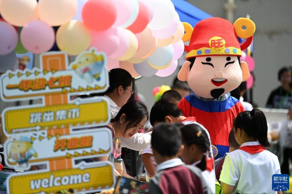 5月31日，兰州市东郊学校的小学生在校园里逛创意义卖市集。新华社记者 陈斌 摄