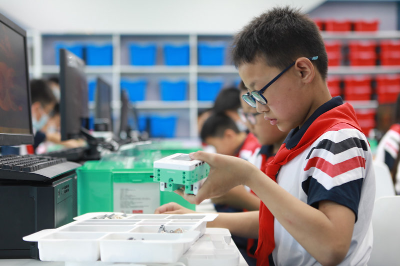 6月1日，在河北省邯郸人工智能教育基地，邯山区代召实验小学学生正在动手组装机器人。（李昊 摄）