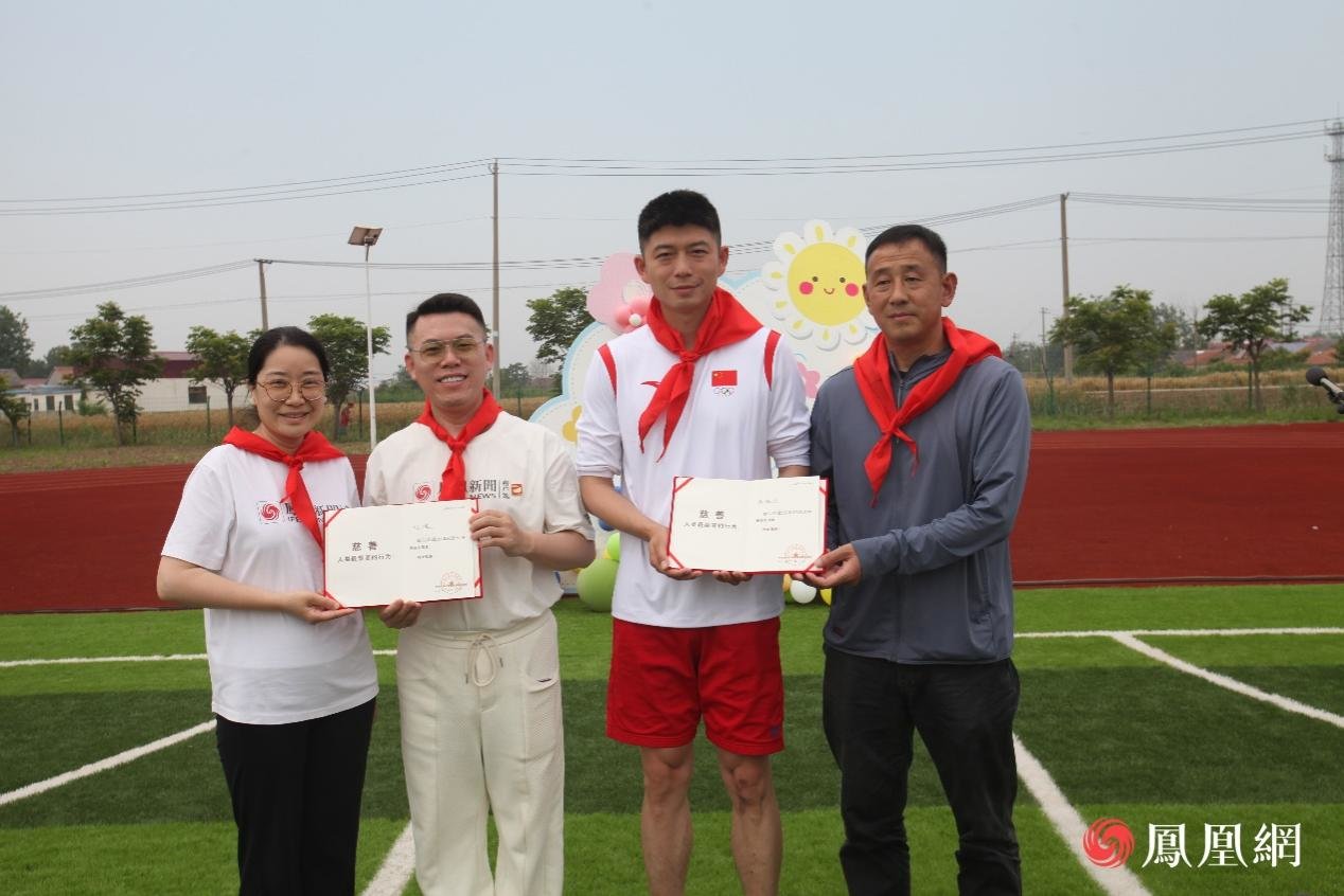凤凰网副总编辑、公益专项基金执行主任侯春艳（左一）灌云县教育局体卫艺处主任黄文卓（右一）向“寻梦计划”志愿者刘健（左二）、龚伟杰（右二）授予荣誉证书