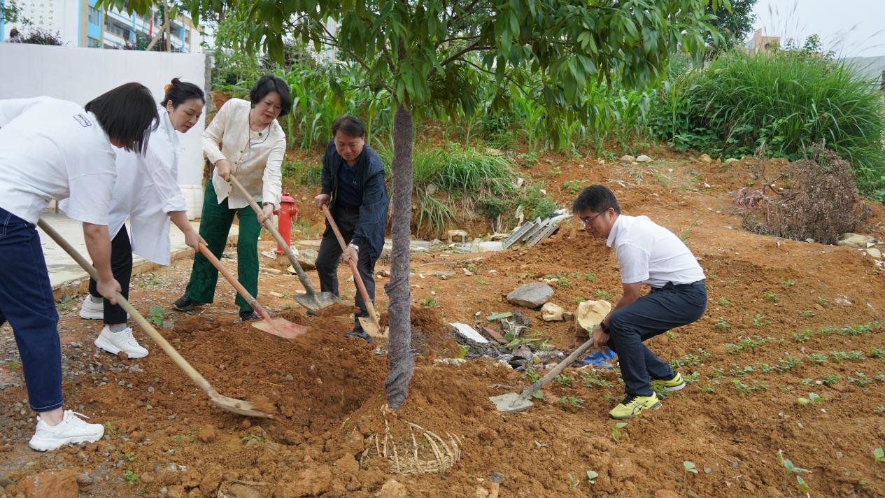 德江县人民政府政府副县长梁健（右一），东莞市凤岗女企业家协会会长洪亦文（左三）等为德江民族中学植下莞德协作“同心树”