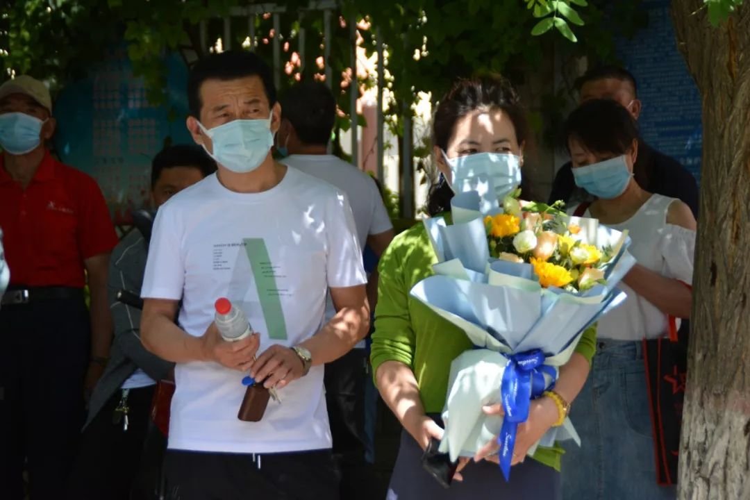 家长手拿向日葵，寓意“一举夺魁”。