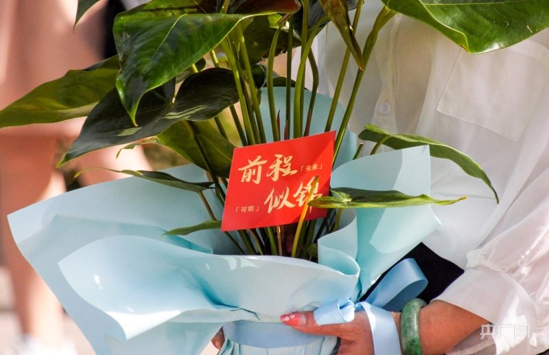 6月8日下午,甘肃省白银市平川区中恒学校考点外,一名家长手捧鲜花,为参加完高考的孩子送上美好祝愿。(央广网发 白银市委宣传部 供图)