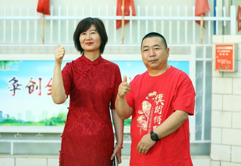 6月7日,在甘肃省酒泉市玉门一中考点外,考生家长身穿旗袍和写有“旗开得胜”字样的衣服,为考生送上美好祝福。(央广网发 陈雪霞 摄)