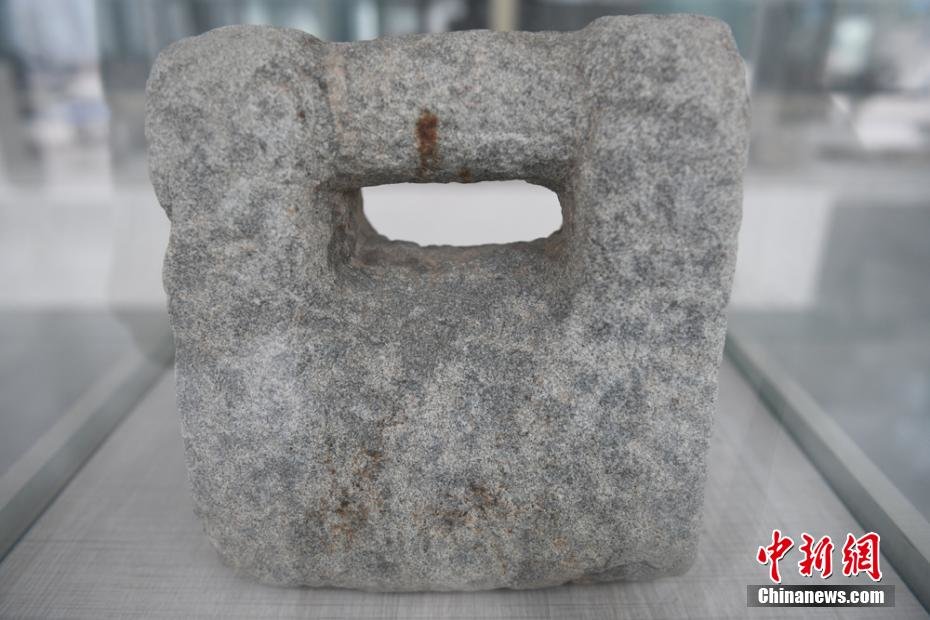 图为乡村农耕博物馆展柜里的撂石锁