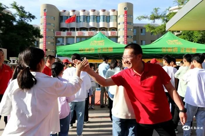 民勤县考点，老师和学生击掌，为他们打气。