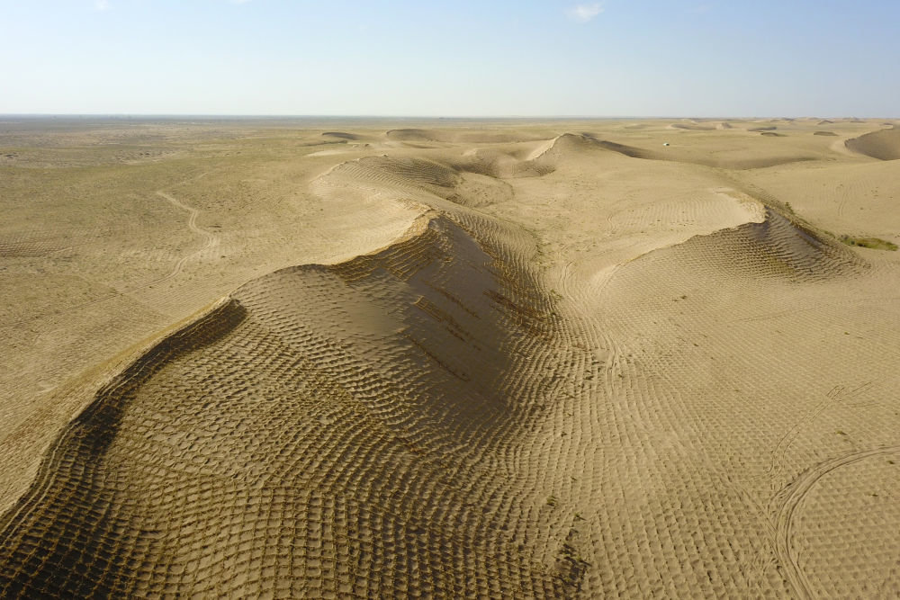 这是5月31日在武威市民勤县沙咀墩机械压沙示范区拍摄的草方格沙障（无人机照片）