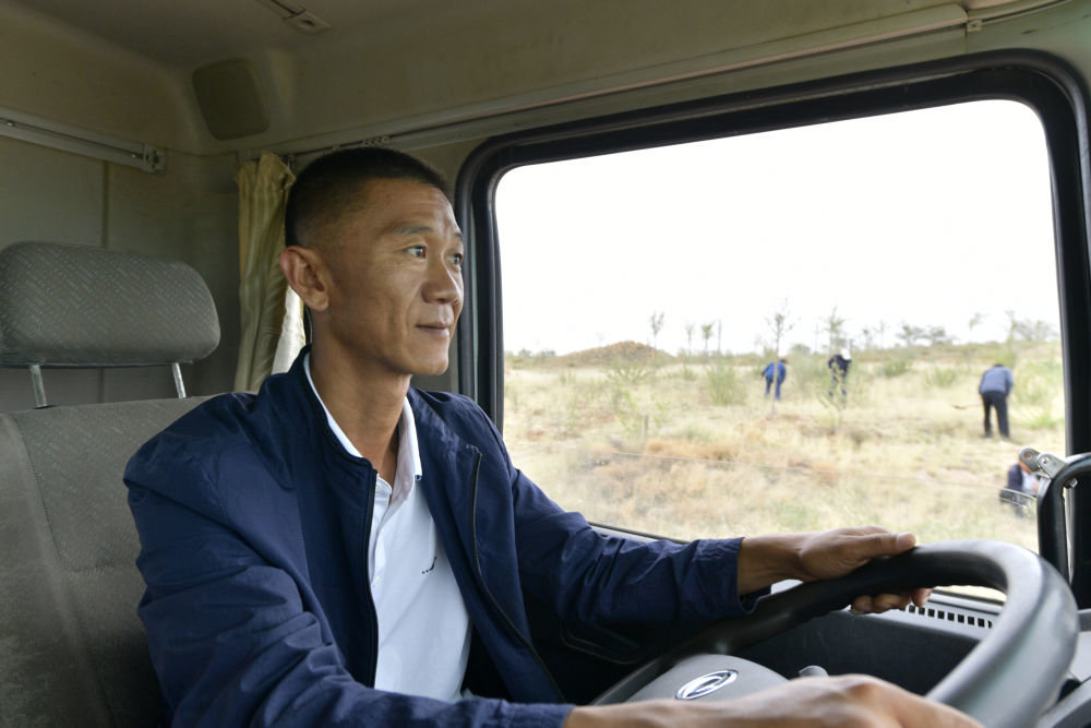 6月2日，八步沙第三代治沙人郭玺开着洒水车去武威市古浪县的一片林区浇水。