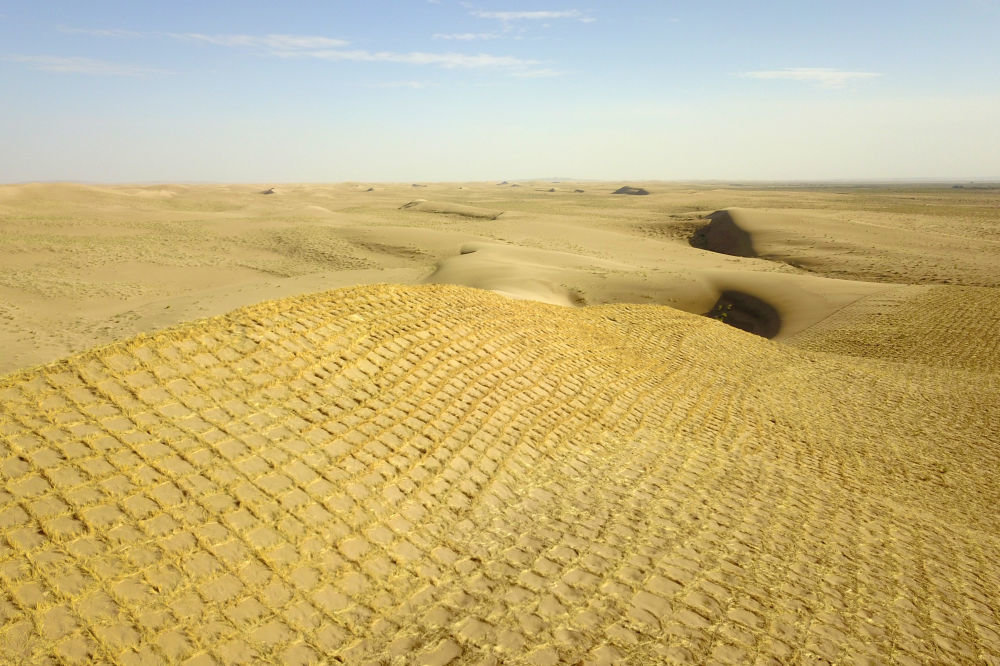 这是5月31日在武威市民勤县沙咀墩机械压沙示范区拍摄的草方格沙障（无人机照片）
