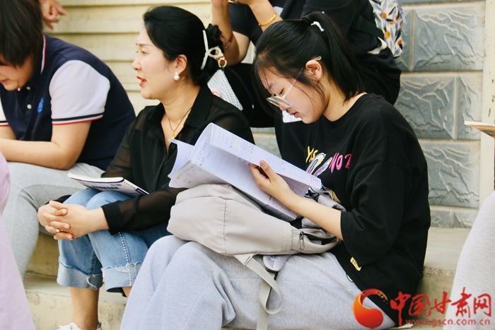 家长陪伴孩子在考场门口温习