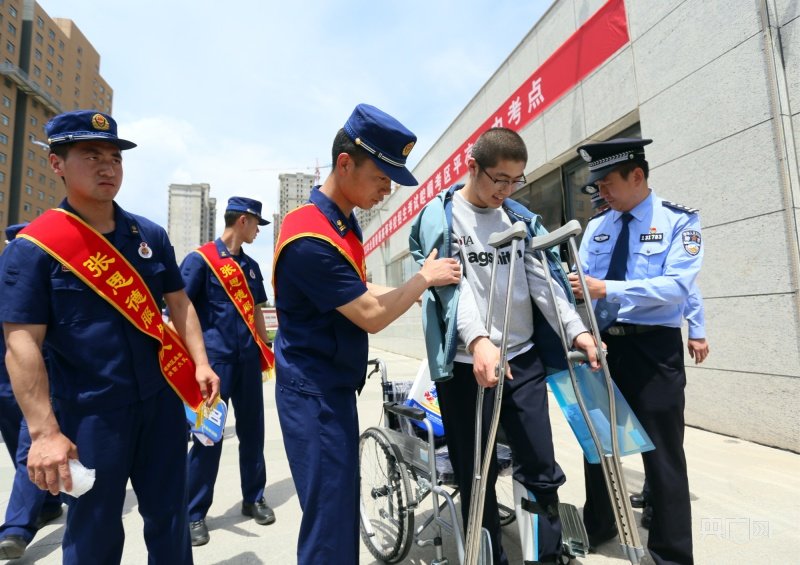 6月7日,甘肃省平凉一中考点,执勤民警和消防志愿者一起,帮助行动不便考生进入考场。(央广网发 平凉市公安局 供图)