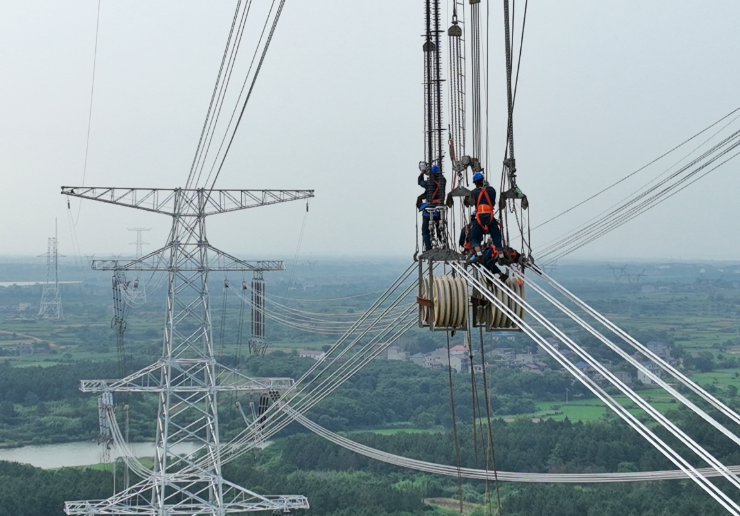 6月3日，武汉～南昌双回1000千伏线路工程鄱阳湖段放线结束后，工作人员在塔上开展紧线、附件安装等作业。
