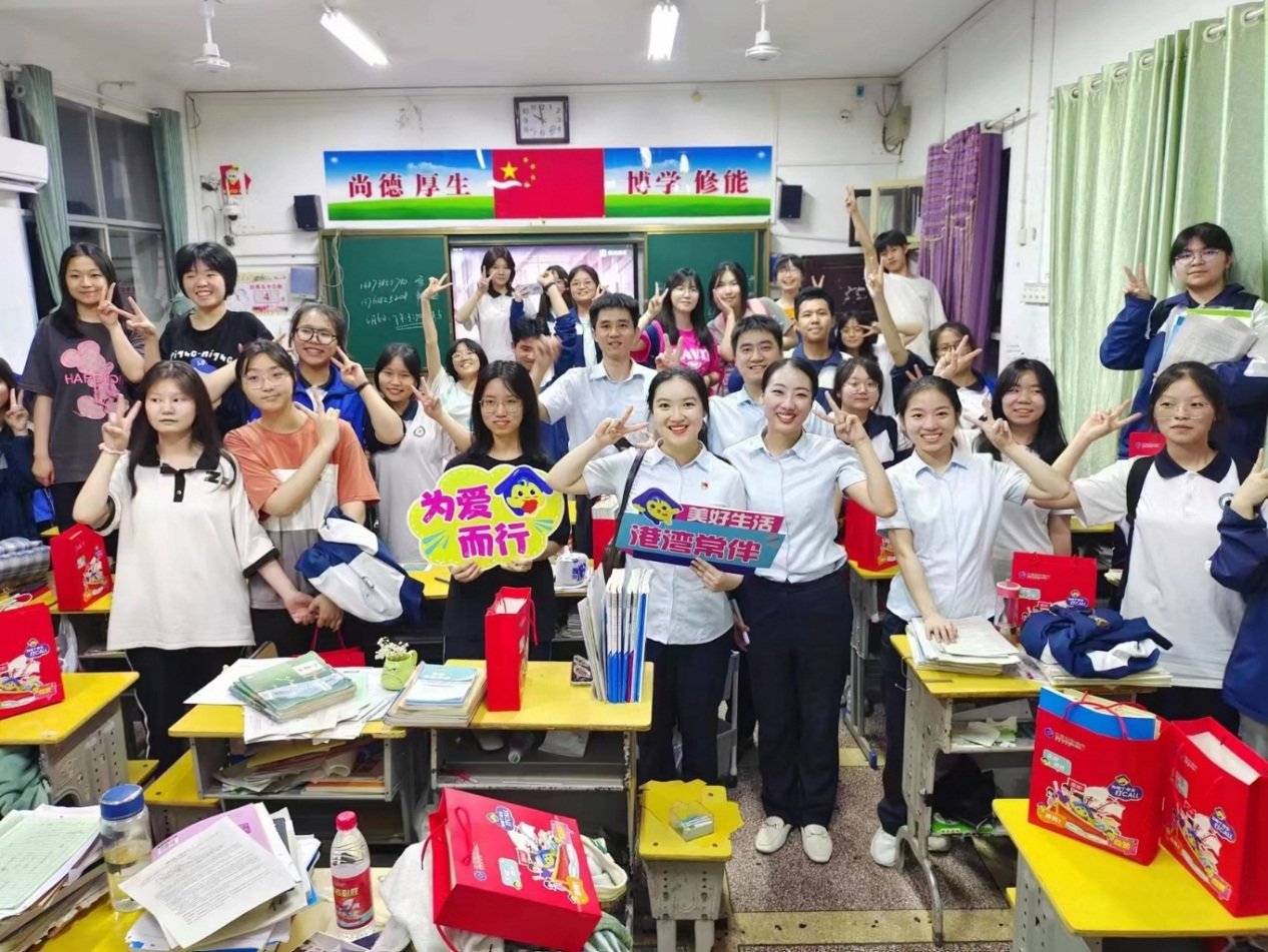 志愿者为毕业班学生送上爱心助考礼包并留影