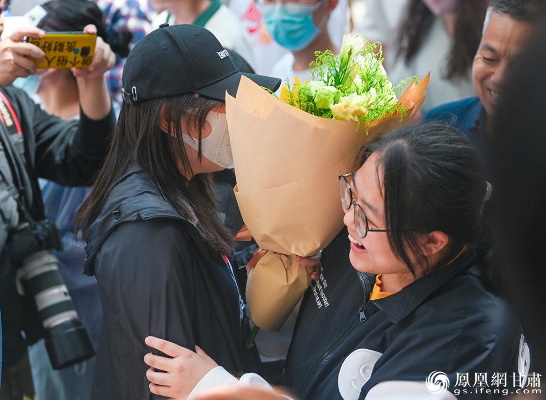 等候多时的家长向孩子送上鲜花与祝福 李德宇 摄