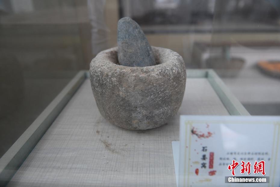 图为乡村农耕博物馆展柜里展示的石姜窝