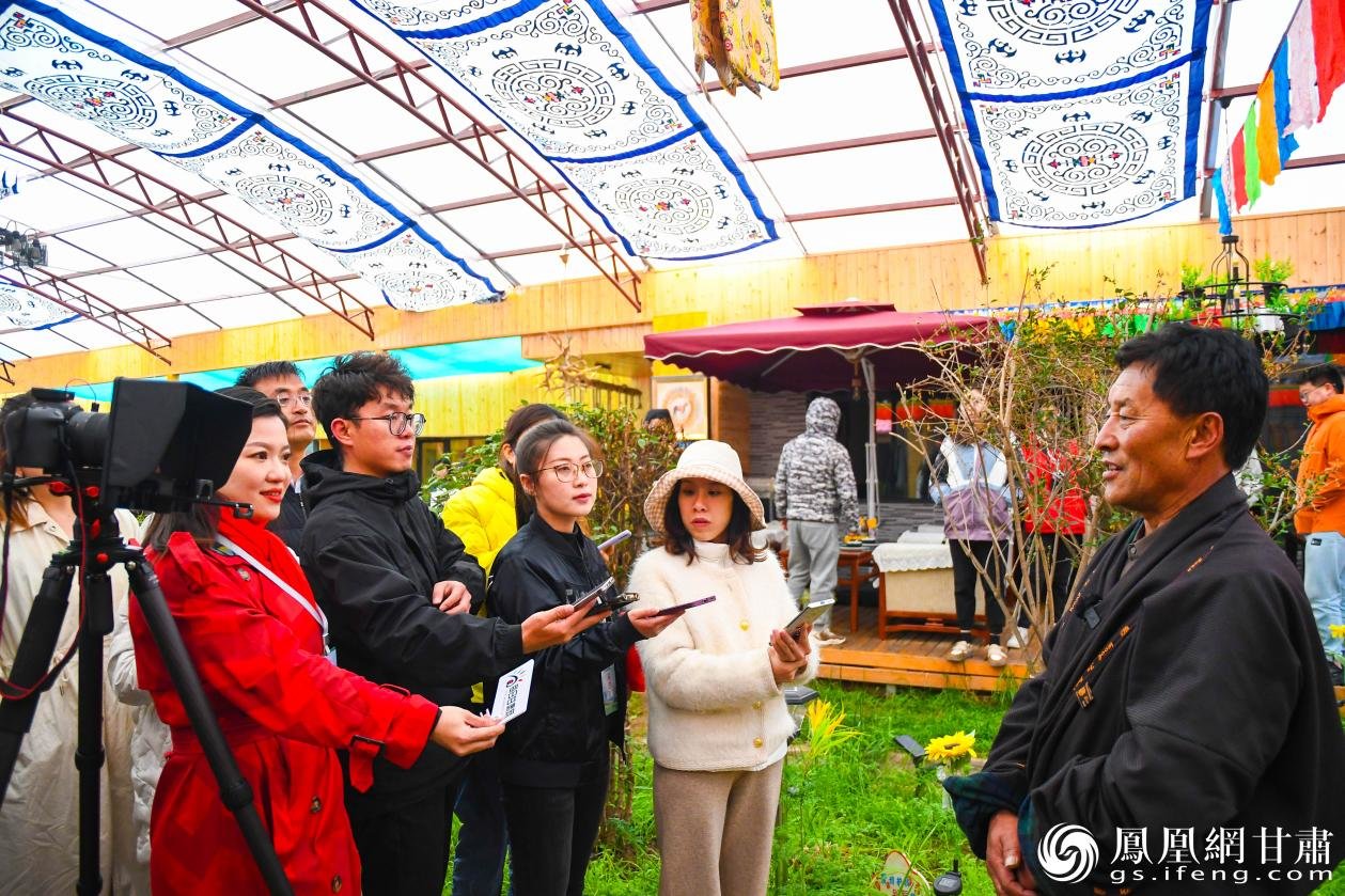 甘肃省甘南州碌曲县尕海镇尕秀村原党支部书记拉毛加（右）向采访团介绍该村历史变迁 李杨 摄