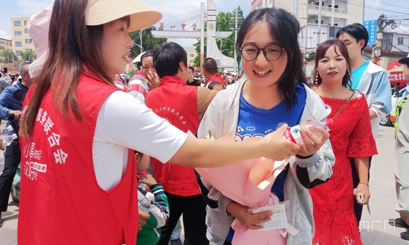 6月7日,甘肃省陇南市成县一中考点门口,志愿者向刚走出考场的考生发放矿泉水。(央广网发 王娟 摄)