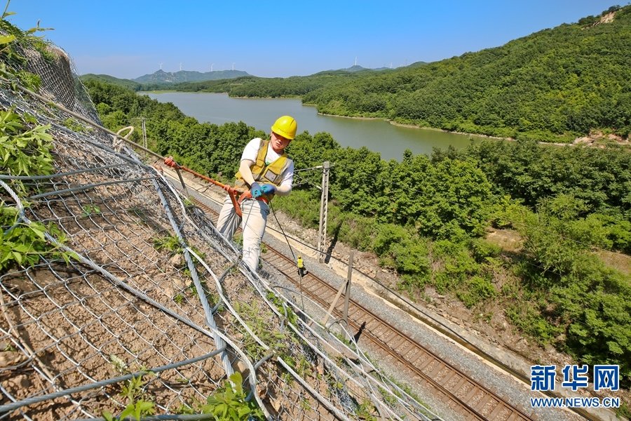 6月6日，南阳工务段组织工人在对焦柳下行线西侧的山体进行防护网加固。
