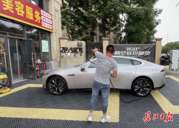 王先生在他的洗车店工作。 记者杨荣峰 摄