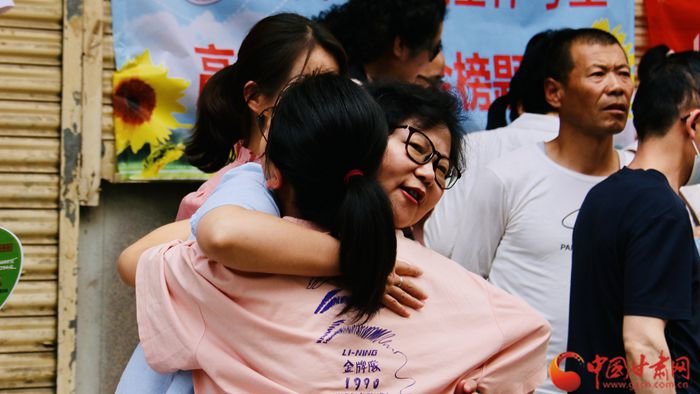 家长与孩子亲切拥抱，为孩子加油打气。