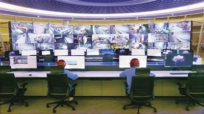 图为工作人员通过大屏幕察看每条生产线的实时状态。