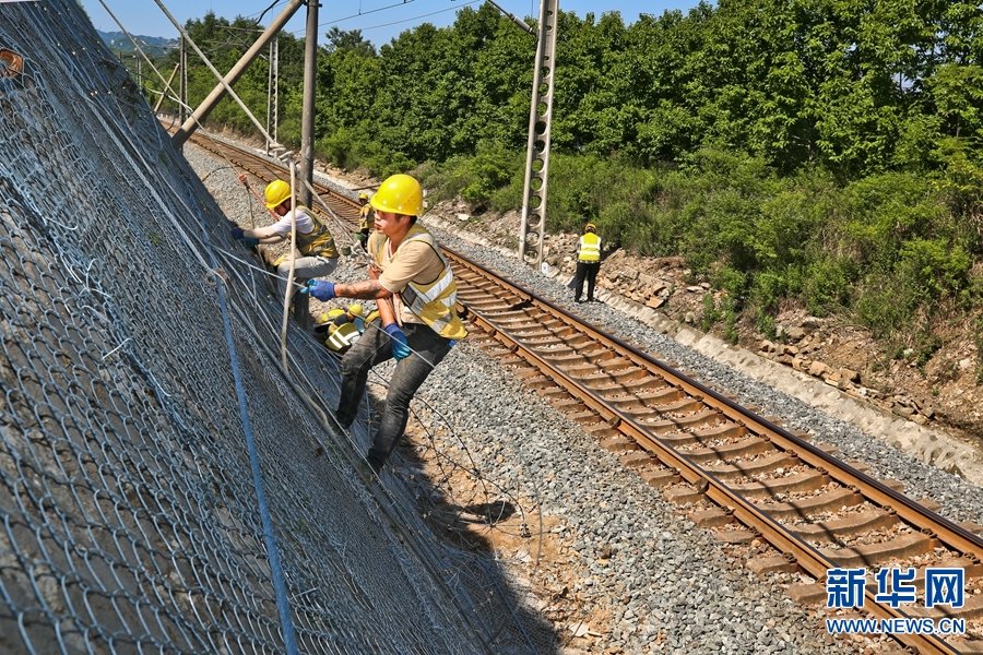 6月6日，南阳工务段组织工人在对焦柳下行线西侧的山体进行防护网加固。