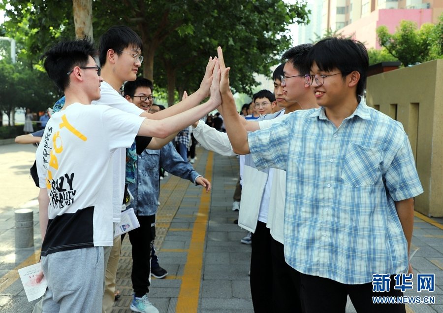6月7日，河南省南阳市第二十一学校考点，考生在考试前相互加油。高嵩 摄