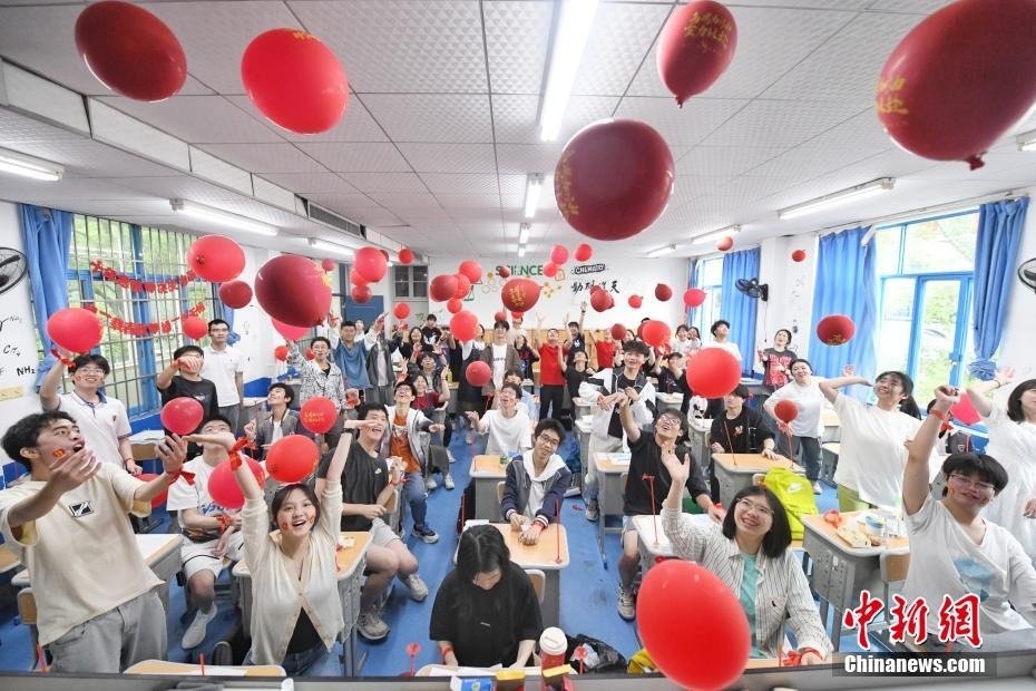 2023年高考前一天，长沙市同升湖高级中学高三年级老师为即将参加高考的考生们派发红包、糕点和粽子，祝福高考生能够金榜题名，一举“糕粽”。杨华峰 摄