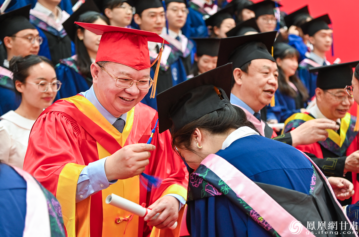 中科院院士、兰州大学校长严纯华(左)为毕业生拨穗正冠 谢帅 摄