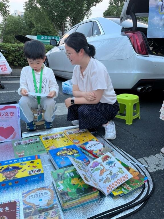 刘芳和儿子邓力源边守摊边学习。