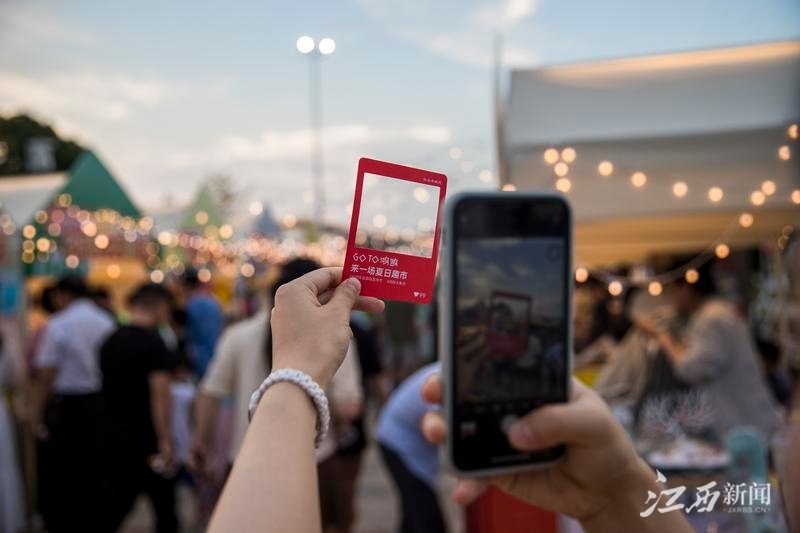 6月10日傍晚，游客在九龙湖&middot;鸿鹄大集市里拍照打卡。