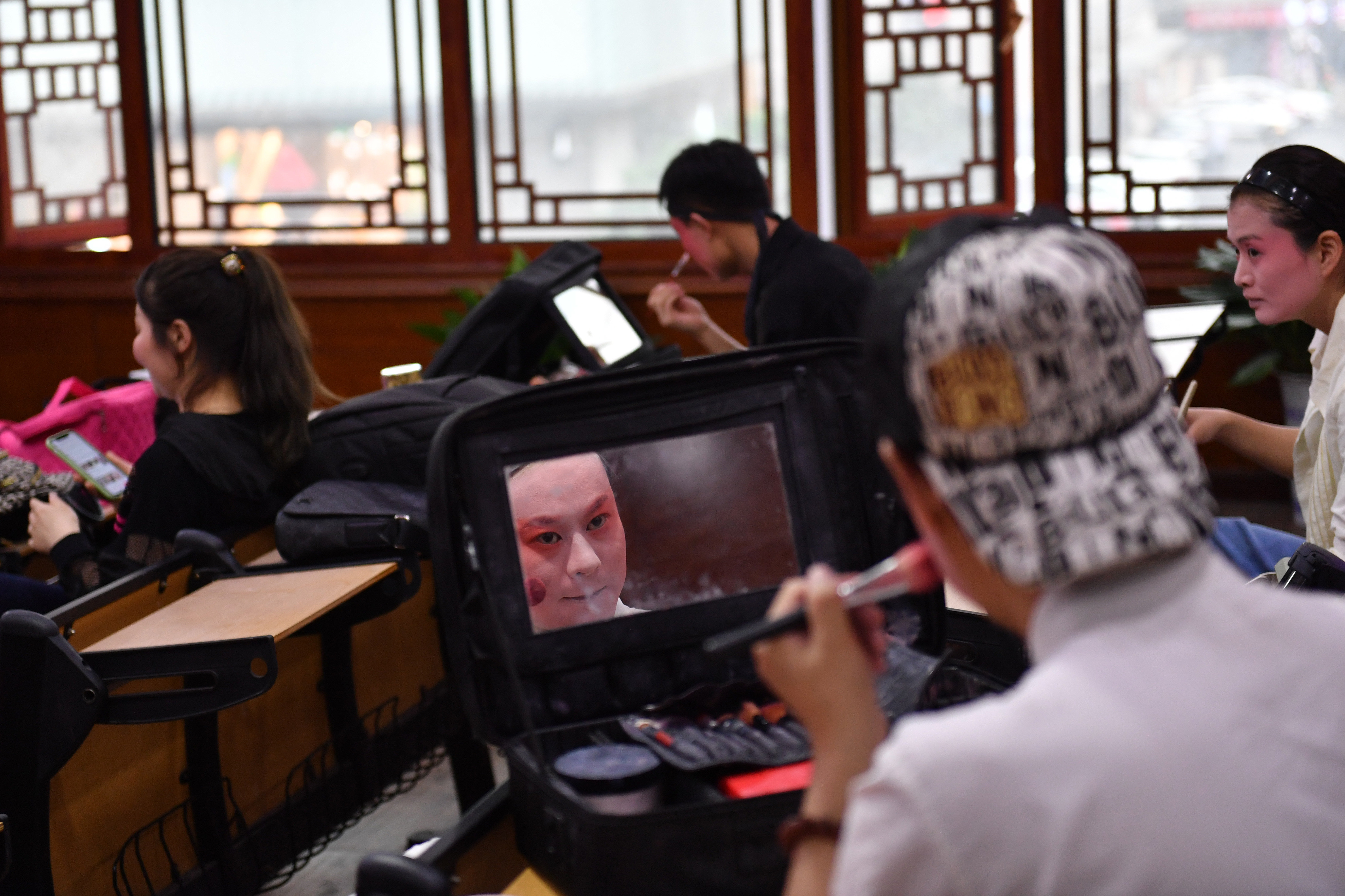 6月5日，在长沙市坡子街火宫殿，长沙市花鼓戏保护传承中心的演员在演出前化妆。新华社记者 陈振海 摄