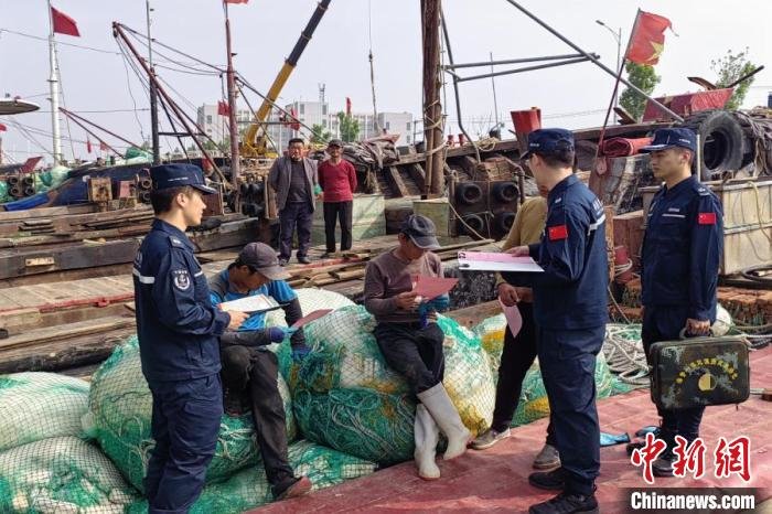海警执法员在陆上走访宣传。　 刘硕 摄