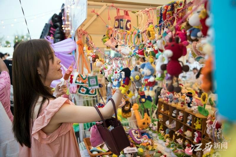 6月10日下午，游客在九龙湖&middot;鸿鹄大集市的摊位前。